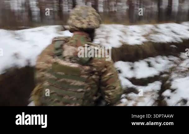 An unrecognizable soldier with a weapon and in full military uniform ...