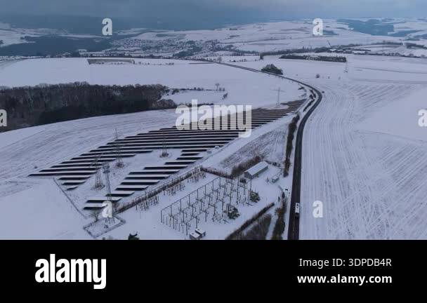 Wind turbine and solar panel in snow, dark doldrums or wind lull in ...