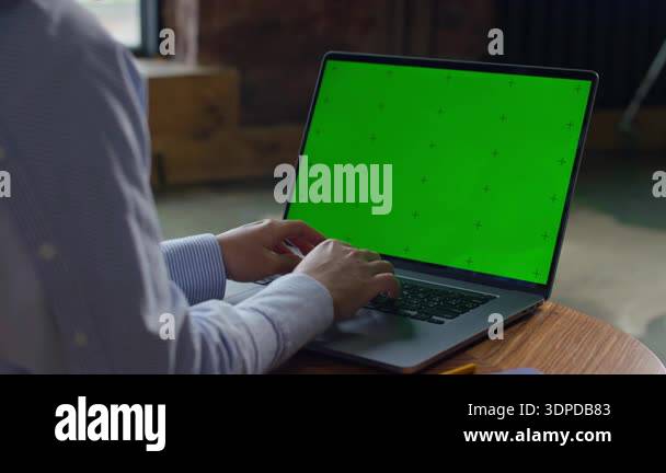 Unrecognizable woman typing on laptop with green screen display, chroma ...
