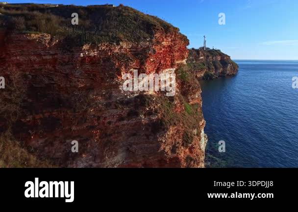 Rugged cliffs rise above the blue water, showcasing the natural ...