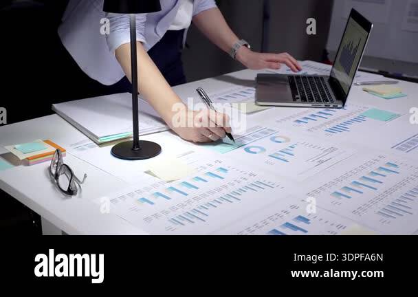 Business professional reviewing financial reports and spreadsheets at a ...