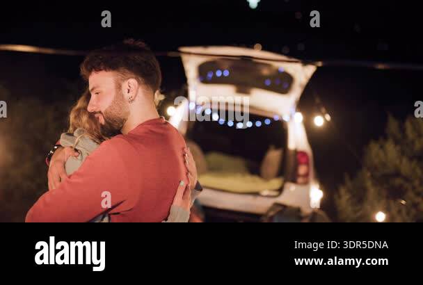 Two people share happy moments while camping at night. They enjoy time ...