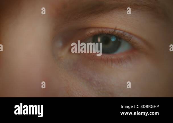 Extreme close-up shot of a persons blue eye, with the pupil dilating ...