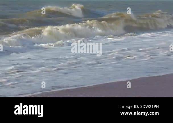 Soft ocean waves rolling gently onto sandy shore, creating serene ...