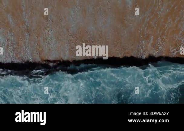 Cinematic slow motion drone shot of powerful ocean waves rolling onto ...