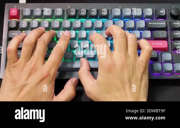 Overhead perspective of colorful gaming keyboard in use. Human hands ...