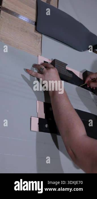 Vertical close up of artisan measuring and marking gray upholstery ...