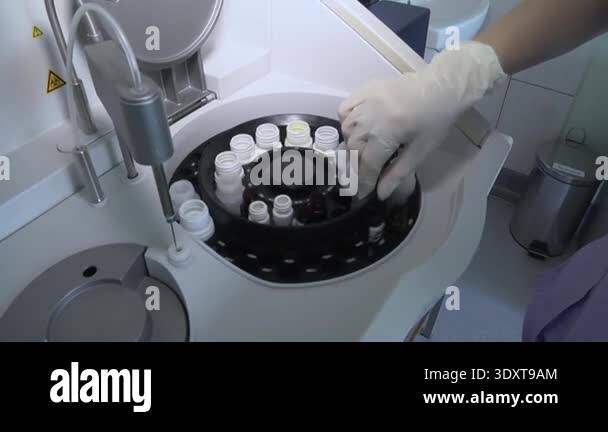 Reagent Carousel A close-up of a healthcare workers hand in a white protective glove ...