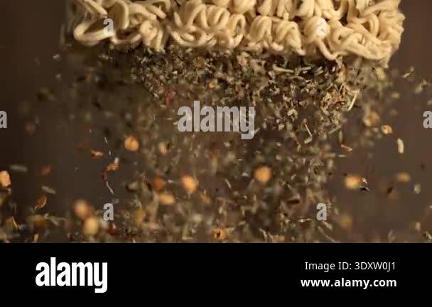 super slow motion closeup instant noodles showered with herbs and ...