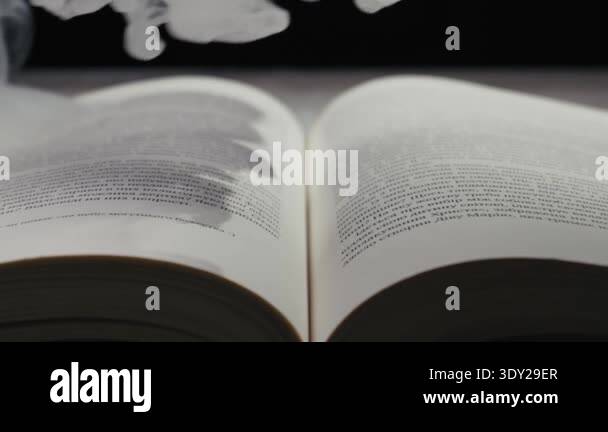 An open book is engulfed by thick, white smoke, obscuring the text on ...