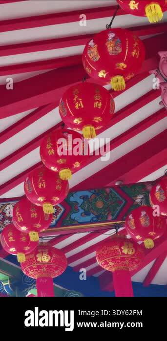 Traditional red Chinese lanterns with gold accents hang in a row ...