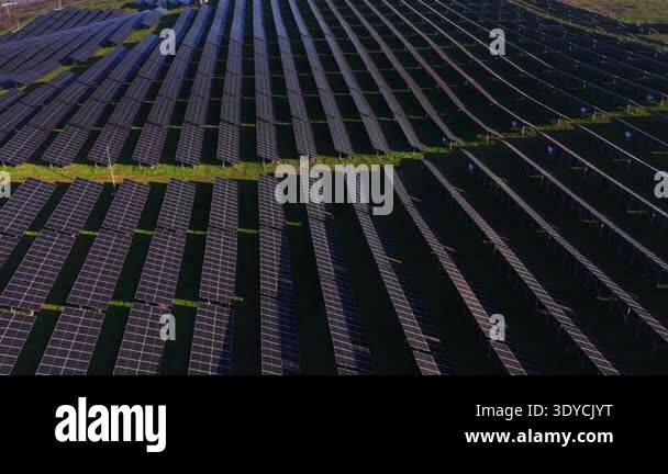 Wide Field Rows Rows of solar panels fill a wide field in a rural area. The panels are ...