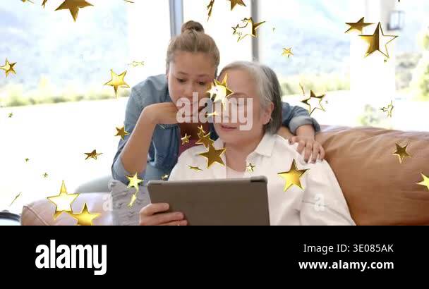 Happiness Device Mature woman tapping tablet, teen leaning over, creating gold stars and ...