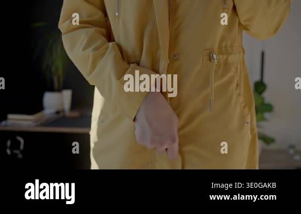 Closeup of woman hands unzipping yellow jacket. Concept of clothing ...