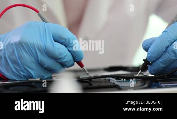 Technician using tool to measure circuit board inspection and repair ...