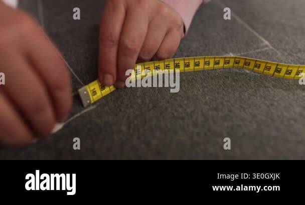 Seamstress uses chalk and measuring tool to mark precise lines on ...