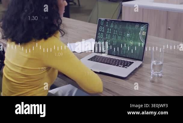 Woman in yellow leaning at table, noticing laptop crypto coin visuals ...