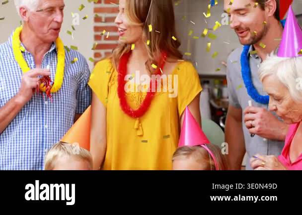 Children blowing lit candles on cake at party table, senior using horn ...