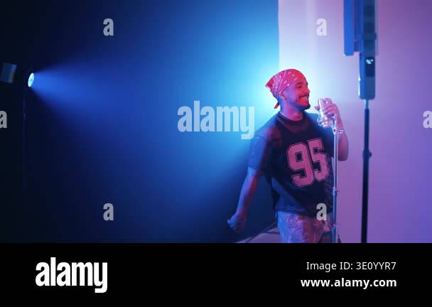 Charismatic male rapper performing a reggaeton song in a studio. The ...