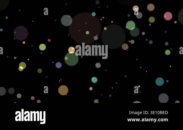 Colorful soft bokeh particles floating on a dark background creating a ...