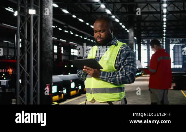 Assembly Supervisor Factory supervisor checks assembly equipment on a tablet in ...