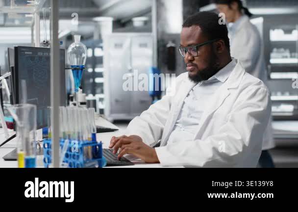 Chemical engineer in lab inspecting chemical compounds in vials for ...