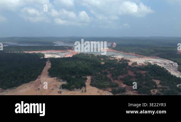 Forward aerial extensive deforestation and land clearing around a silty ...