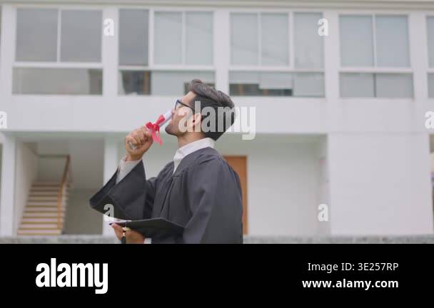 Graduate holding diploma wearing black gown Stock Video Footage - Alamy
