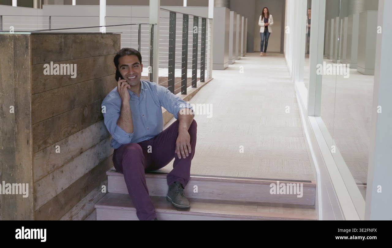 Millennial talking on cell phone at work Stock Video Footage - Alamy