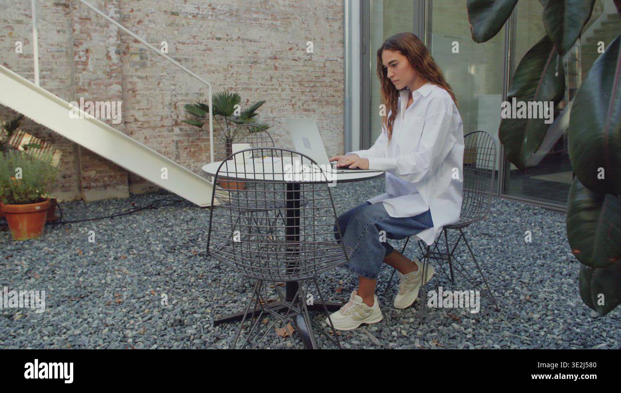 Woman with laptop in yard Stock Video Footage - Alamy
