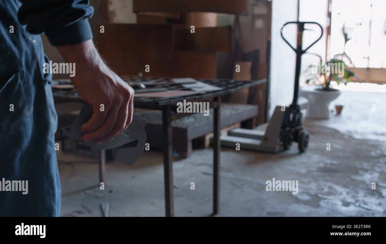 Sculptor bringing paper stencils to workbench Stock Video Footage - Alamy