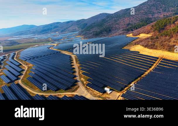 Aerial perspective of solar energy farm following terrain. Wide drone ...