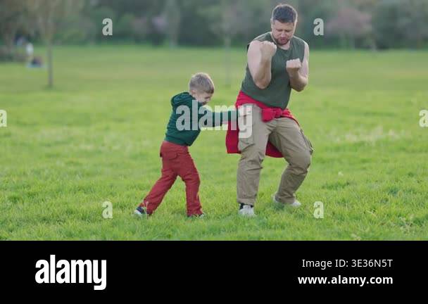 Happy family having fun while play fighting in a park during a sunny ...