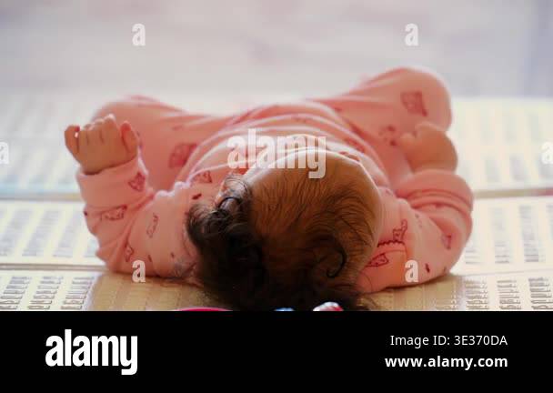 Baby lying on a play mat surrounded by colorful toys during playtime ...