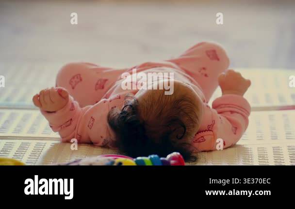 Baby lying on a play mat surrounded by colorful toys during playtime ...