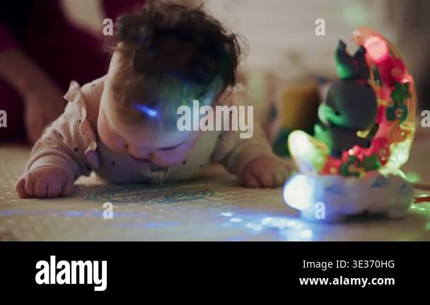 Close up of infant lying on play mat during playtime while caregiver ...