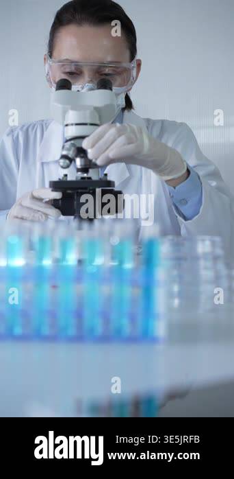 Woman scientist wearing lab coat, white protective gloves and glasses ...