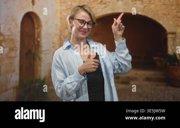 Woman wearing glasses smiling and making thumbs up with both hands and ...