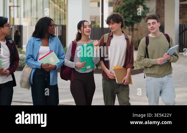Multicultural friends walking together, enjoying student life in modern ...