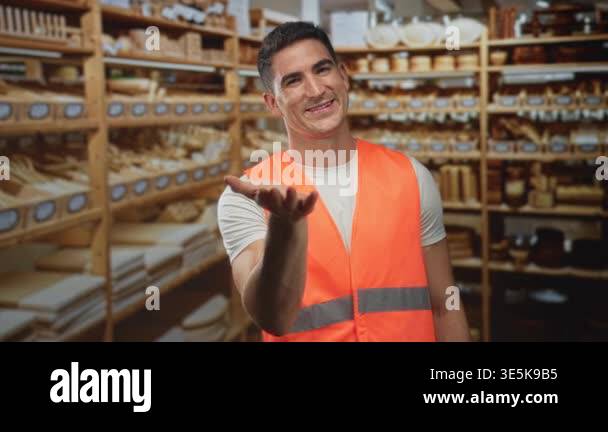 Man in orange safety vest extends open hand palm up amid packed wooden ...