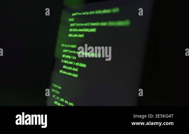 Computer laptop with green programming code lines on display in dark ...