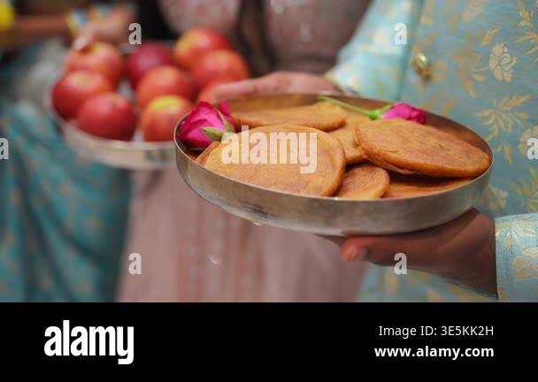 Women holding traditional offering plates with ceremonial items during ...