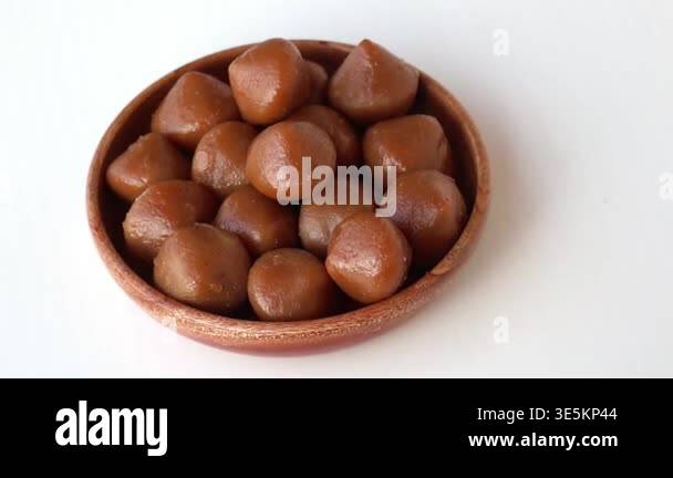 Traditional Bangladeshi Mera Pitha sweets served in a wooden bowl ...