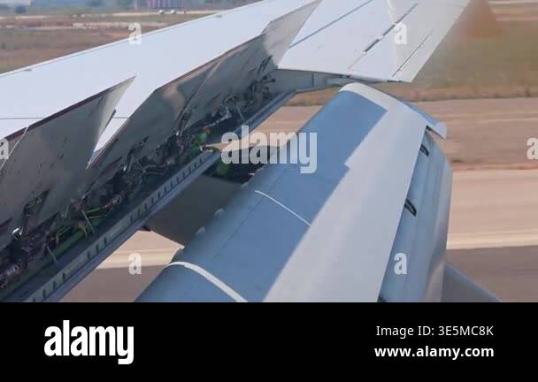 Airplane wing flaps and slats operation during landing from window view ...