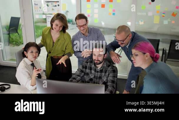 Group of professionals engages in a team discussion around a computer ...