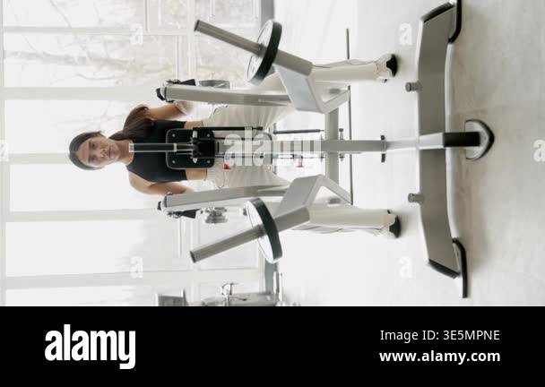 Athletic woman strengthening her back muscles on a seated row machine ...