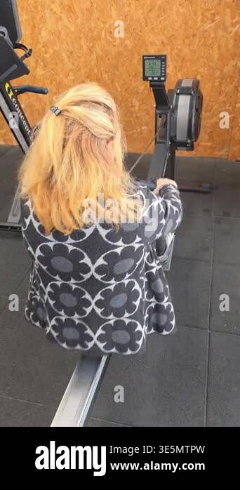 Woman exercising on rowing machine in fitness gym. Cardio workout and ...