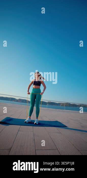 Athletic woman in sportswear doing an upright row exercise with a ...