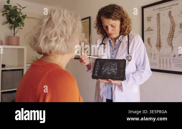 Professional female doctor showing a senior patient her mri scan ...