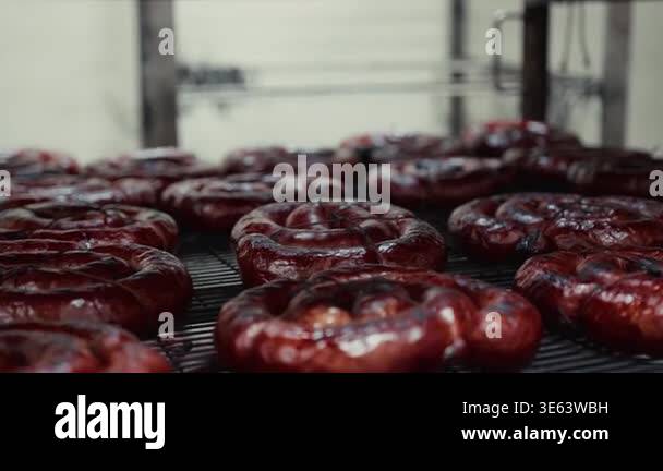 Smoked sausages displayed on a wire rack in a kitchen, emphasizing ...
